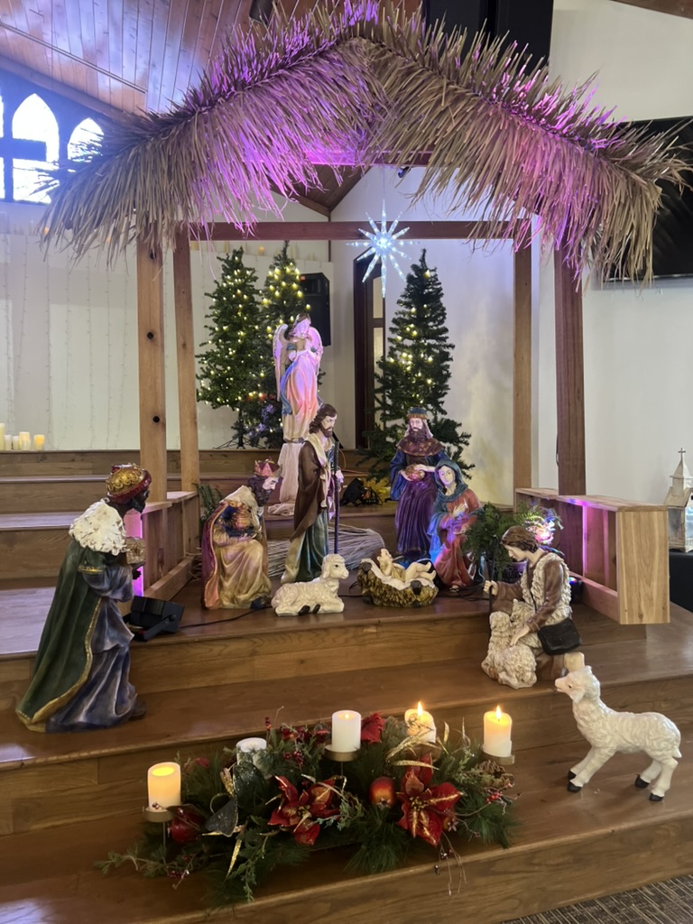 Nativity scene with figurines under a straw manger